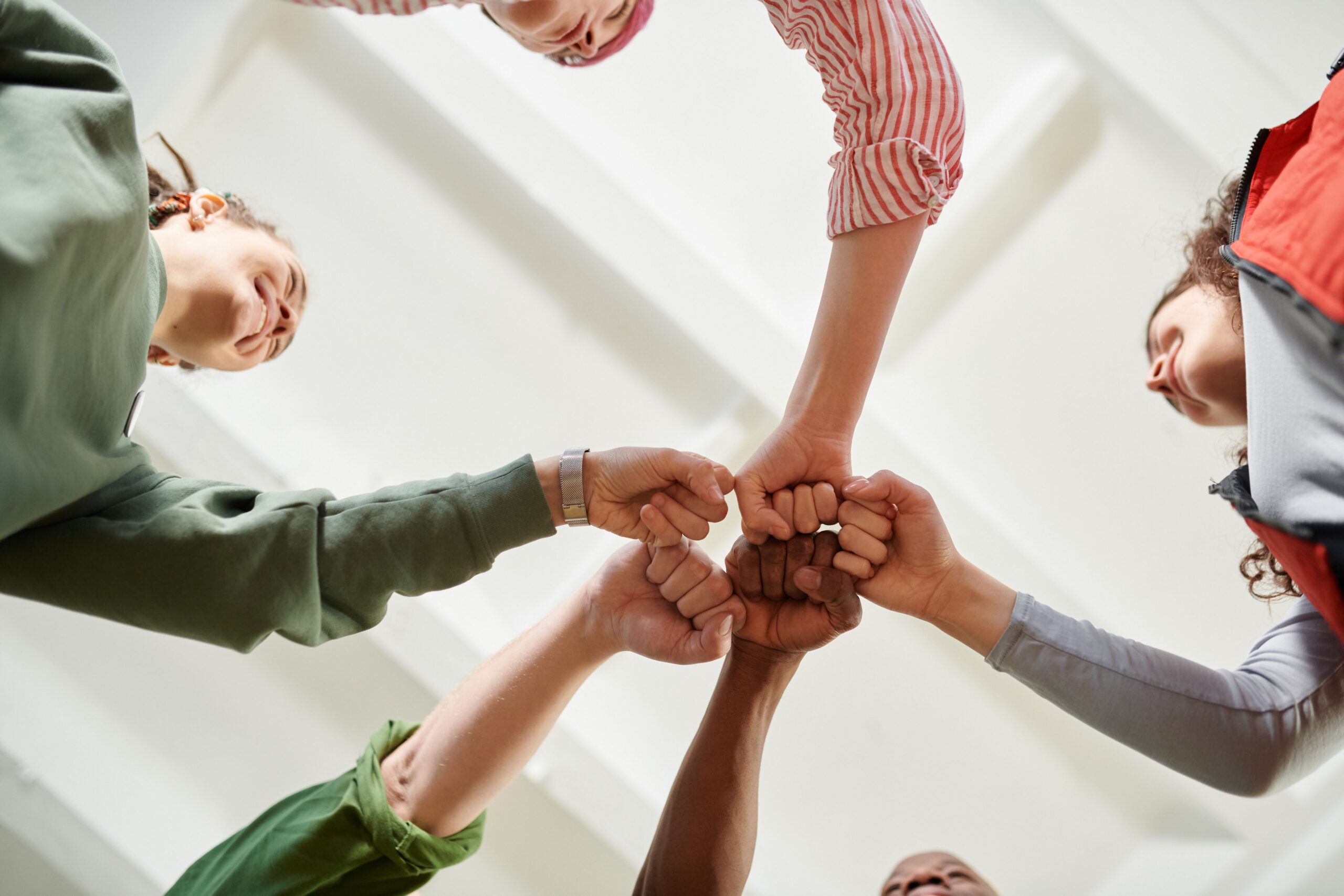 People in a circle formation doing a fist bump.